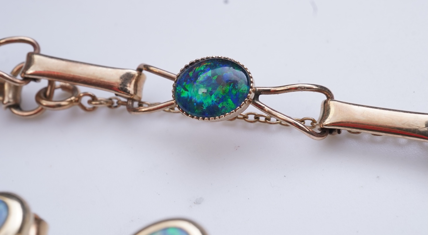 An opal triplet bracelet and pair of earrings, comprising: a gold bracelet set with opal triplets, length 18cm; and a pair of studs set with opal doublets, mounted in gold, length 0.8cm each, post fittings, stamped 585,
